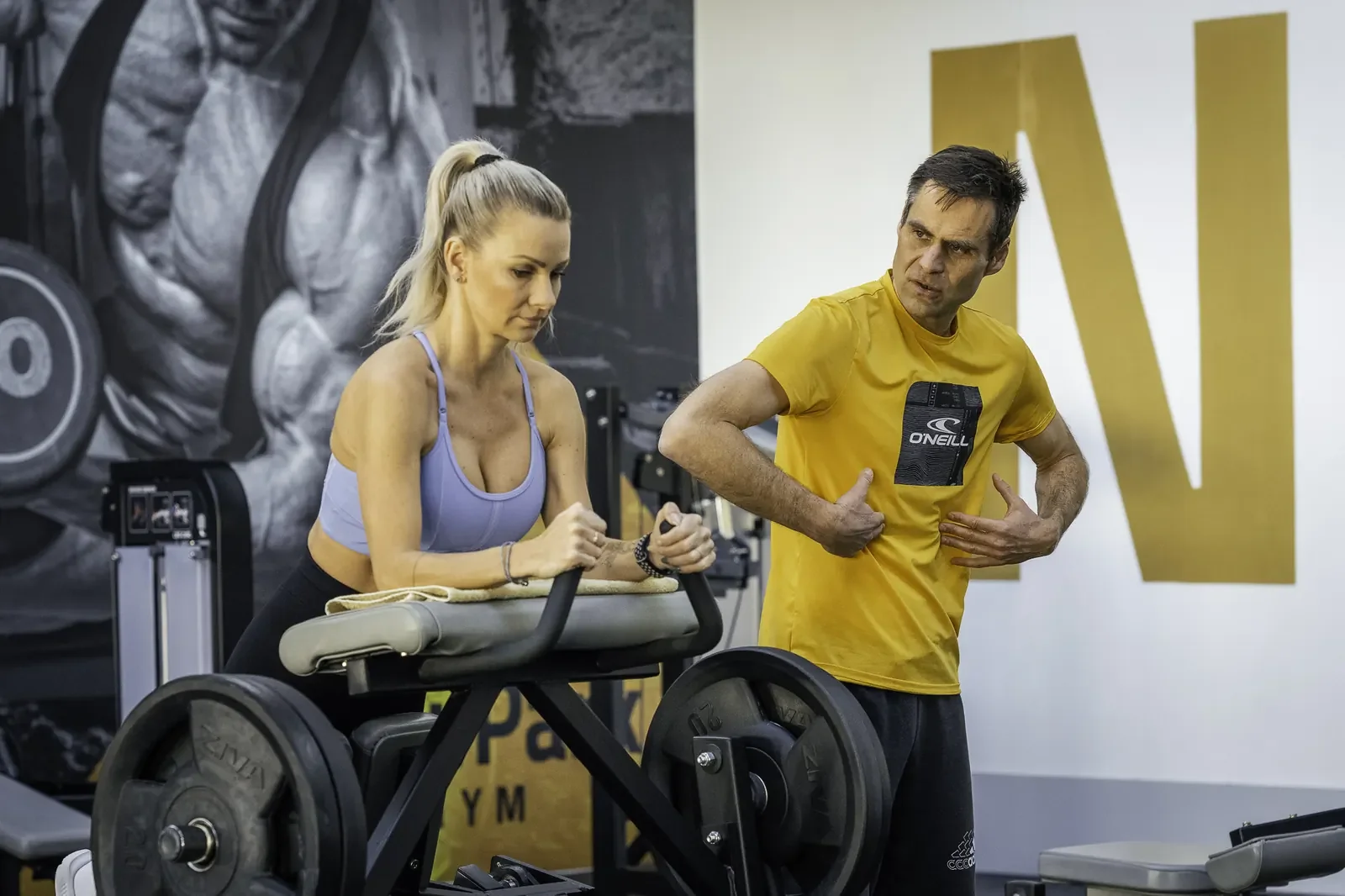 Klientka cvičí na posilovacím stroji pod vedením Michala Kroupy